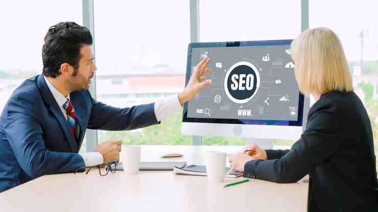 On-page SEO services discussed by professionals with an SEO diagram on a computer screen.