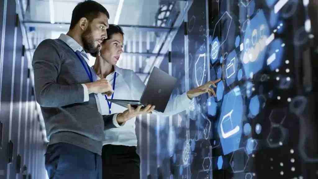 IT professionals managing data in a high-tech server room with digital interface – Top cloud computing services for secure and scalable solutions.